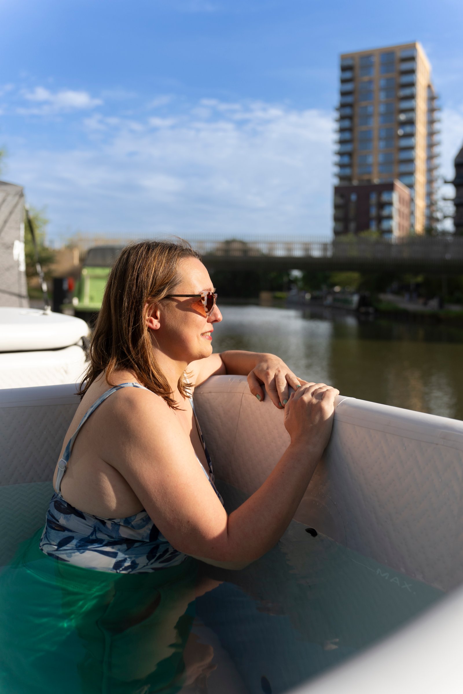 Woman relaxing in an ice bath in the sunshine